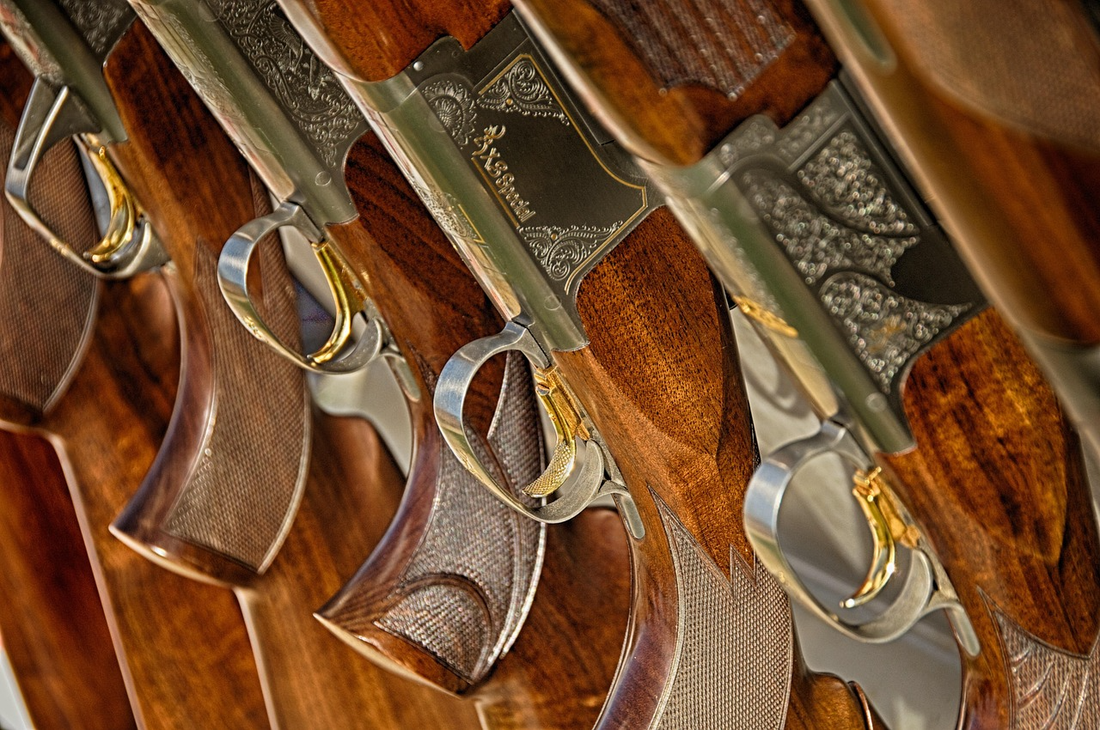 Hunting rifles on a wood rack — Essential hunting gear — Leash The Wilderness