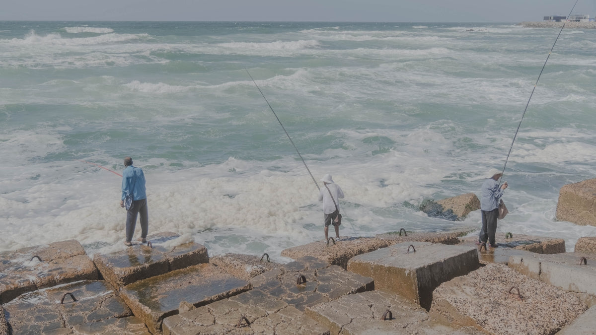 a few men fishing in the ocean